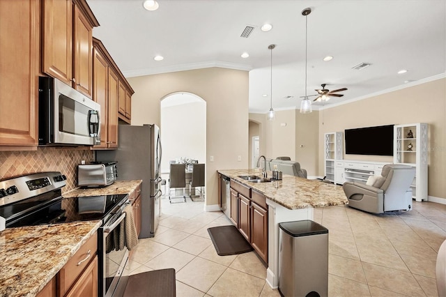 kitchen with pendant lighting, backsplash, sink, ornamental molding, and stainless steel appliances