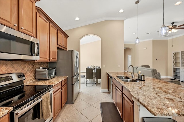 kitchen with sink, stainless steel appliances, crown molding, decorative light fixtures, and light tile patterned floors