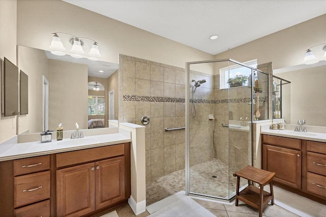 bathroom featuring tile patterned flooring, a tile shower, and vanity