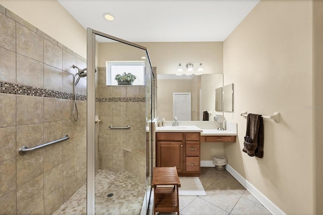 bathroom with tile patterned flooring, vanity, and tiled shower