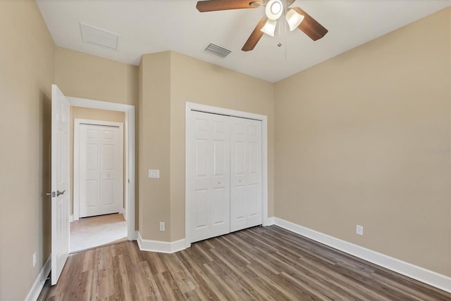 unfurnished bedroom with wood-type flooring, a closet, and ceiling fan