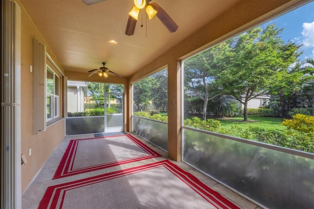 unfurnished sunroom featuring ceiling fan