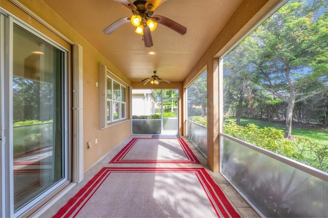 unfurnished sunroom with ceiling fan