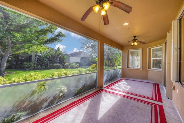 unfurnished sunroom with ceiling fan