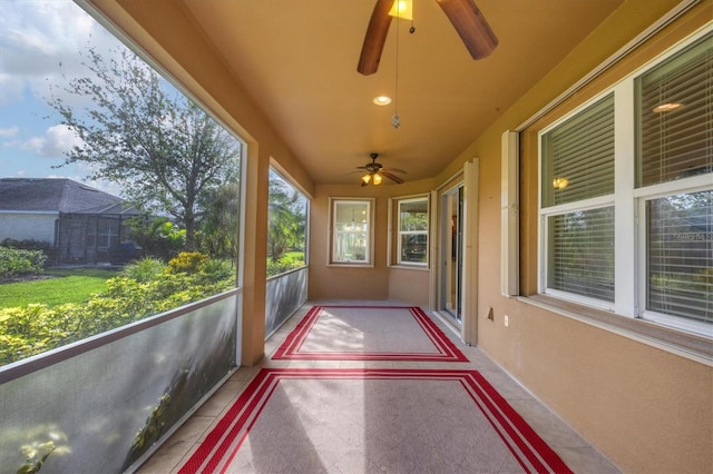 unfurnished sunroom with ceiling fan