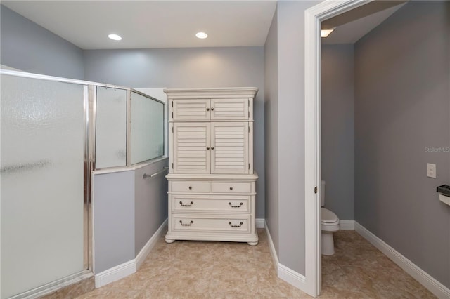 bathroom with toilet and a shower with shower door