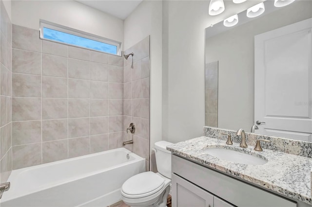 full bathroom featuring vanity, tiled shower / bath combo, and toilet