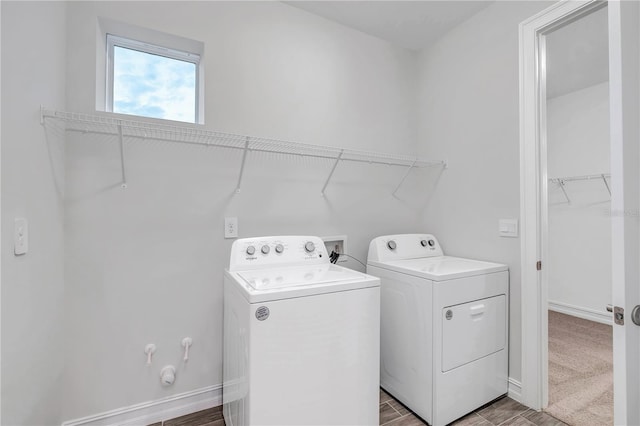 clothes washing area featuring wood-type flooring and separate washer and dryer