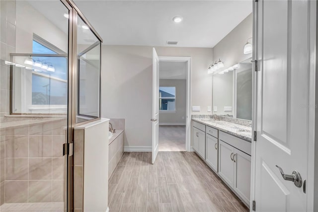 bathroom with vanity, separate shower and tub, and wood-type flooring