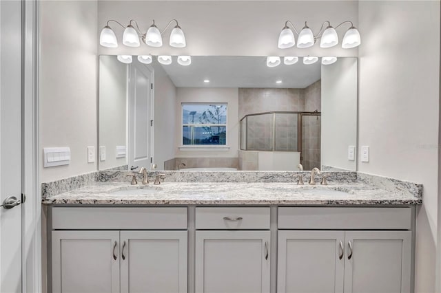 bathroom with vanity and a shower with door