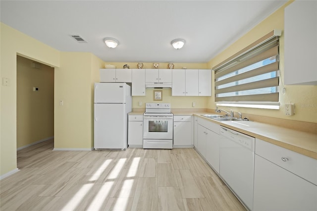 kitchen with white cabinetry, sink, white appliances, and light hardwood / wood-style flooring