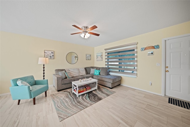 living room featuring a textured ceiling and ceiling fan