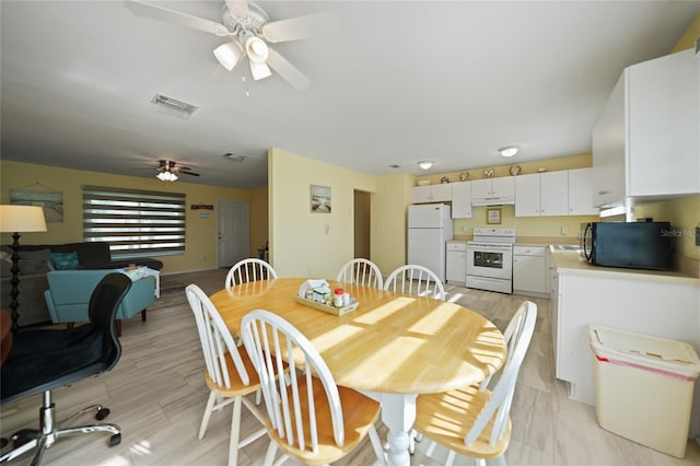 dining room with ceiling fan and light hardwood / wood-style flooring