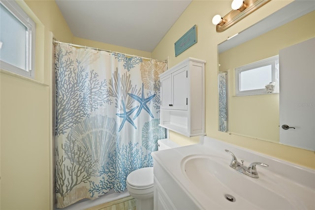 bathroom featuring a shower with curtain, vanity, toilet, and vaulted ceiling