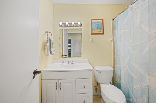 bathroom featuring vanity, toilet, and curtained shower