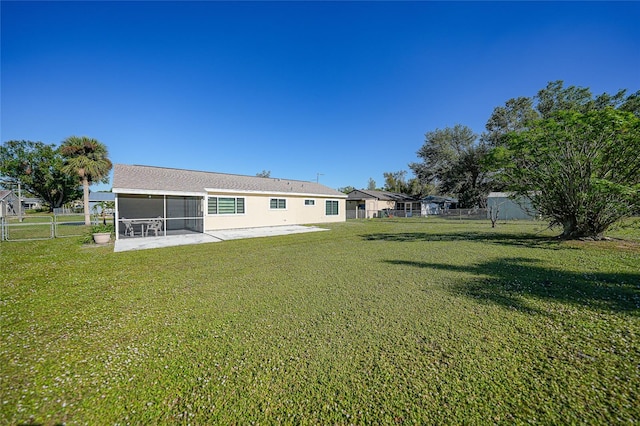 back of property with a patio area, a sunroom, and a yard