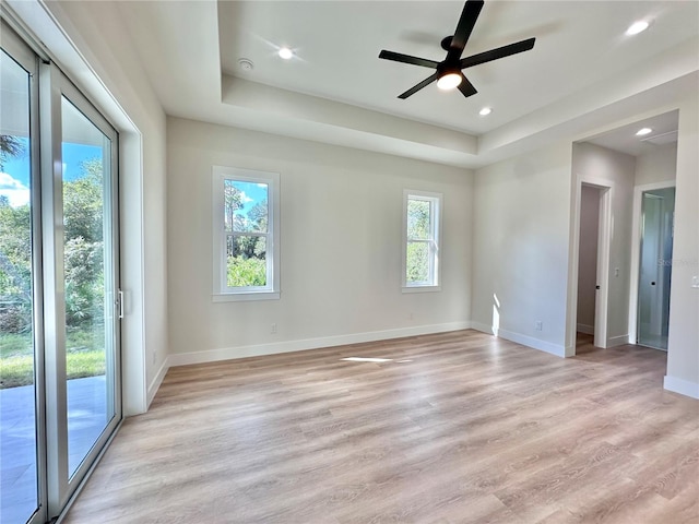 spare room featuring plenty of natural light, ceiling fan, and light wood-type flooring