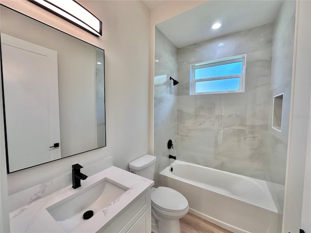 full bathroom featuring toilet, hardwood / wood-style floors, vanity, and tiled shower / bath