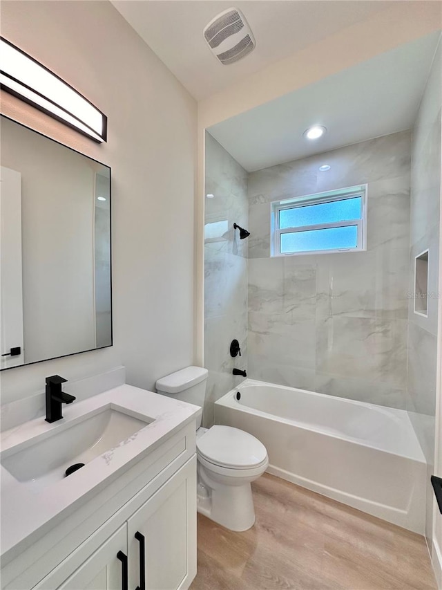 full bathroom with toilet, vanity, tiled shower / bath combo, and hardwood / wood-style flooring