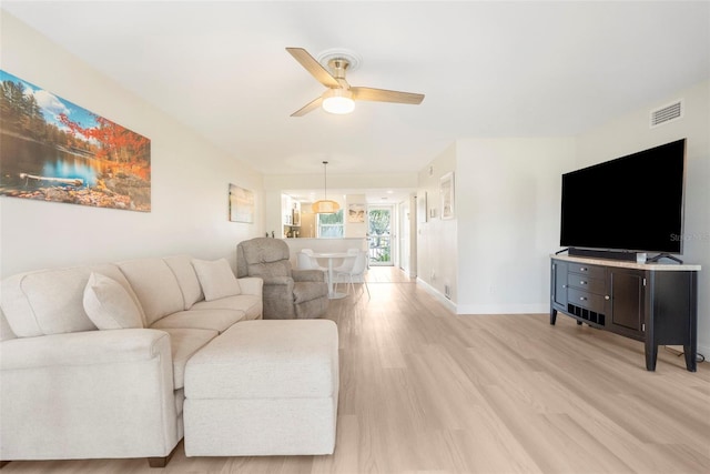 living room featuring ceiling fan and light hardwood / wood-style floors