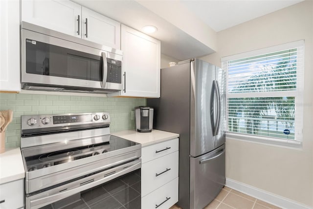 kitchen featuring decorative backsplash, light tile patterned flooring, white cabinetry, and stainless steel appliances