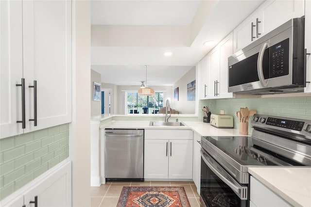 kitchen with white cabinets, appliances with stainless steel finishes, light tile patterned floors, and sink