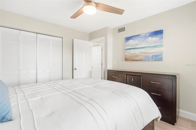 bedroom featuring ceiling fan, light hardwood / wood-style flooring, and a closet