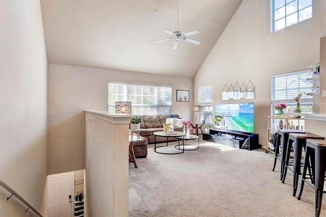 carpeted living room featuring a wealth of natural light, high vaulted ceiling, and ceiling fan