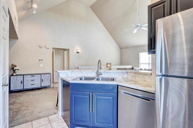 kitchen with high vaulted ceiling, sink, ceiling fan, light colored carpet, and stainless steel appliances