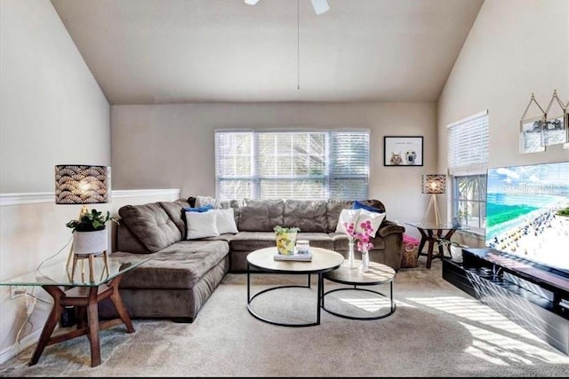 living room featuring lofted ceiling, light colored carpet, and a healthy amount of sunlight