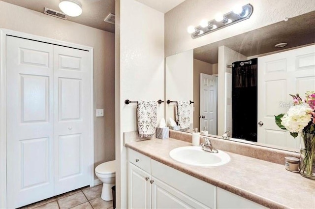 bathroom with tile patterned floors, vanity, and toilet