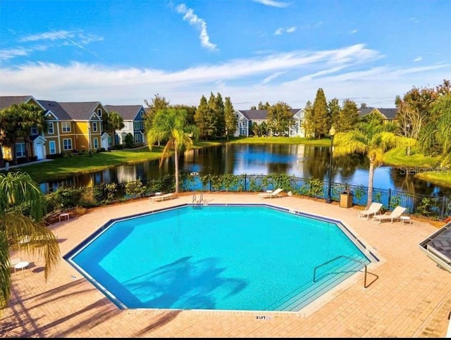 view of pool featuring a patio and a water view