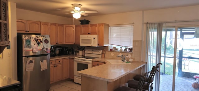 kitchen featuring sink, light tile patterned floors, ceiling fan, kitchen peninsula, and white appliances