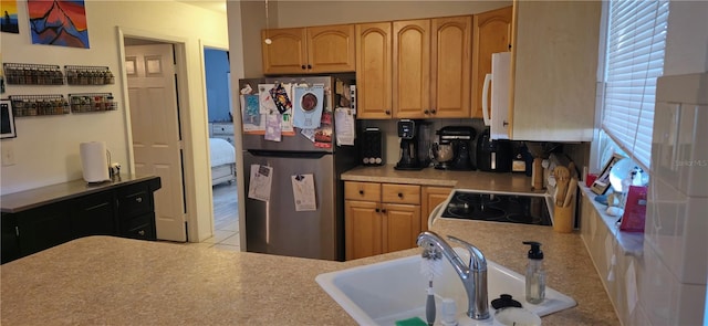 kitchen featuring sink, range, and stainless steel fridge