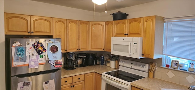 kitchen with light brown cabinetry, backsplash, and white appliances