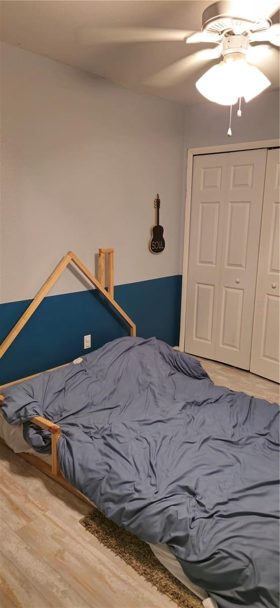 bedroom featuring hardwood / wood-style flooring, a closet, and ceiling fan