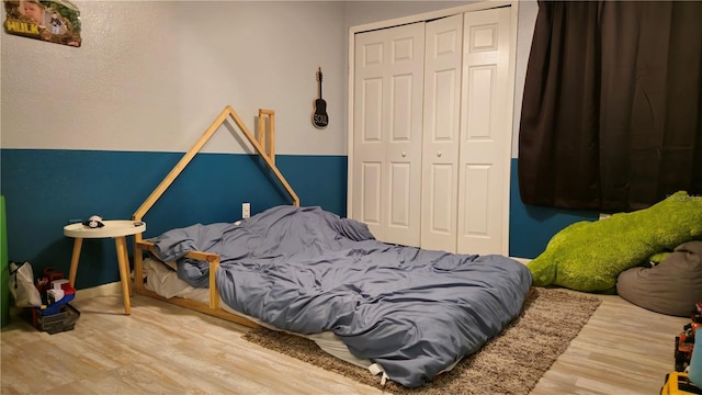 bedroom with hardwood / wood-style floors and a closet