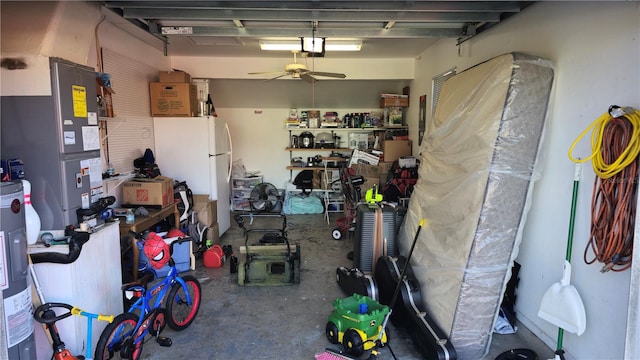 garage featuring white refrigerator, heating unit, ceiling fan, and water heater