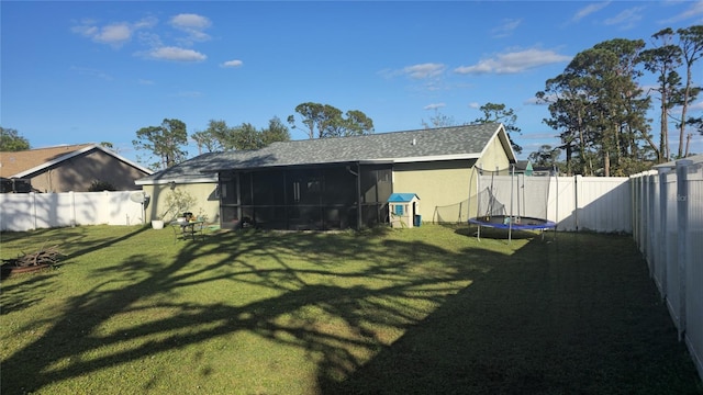 view of yard with a sunroom and a trampoline