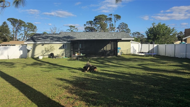 rear view of property with a lawn and a sunroom