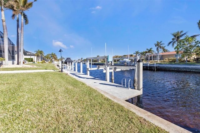 dock area with a lawn and a water view