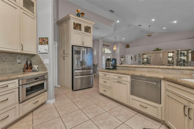 kitchen with appliances with stainless steel finishes, backsplash, lofted ceiling, and cream cabinets