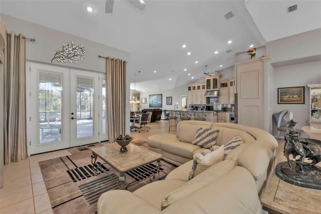 living room with ceiling fan, french doors, light tile patterned flooring, and vaulted ceiling