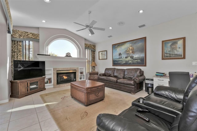 living room featuring ceiling fan, light tile patterned floors, a premium fireplace, and vaulted ceiling