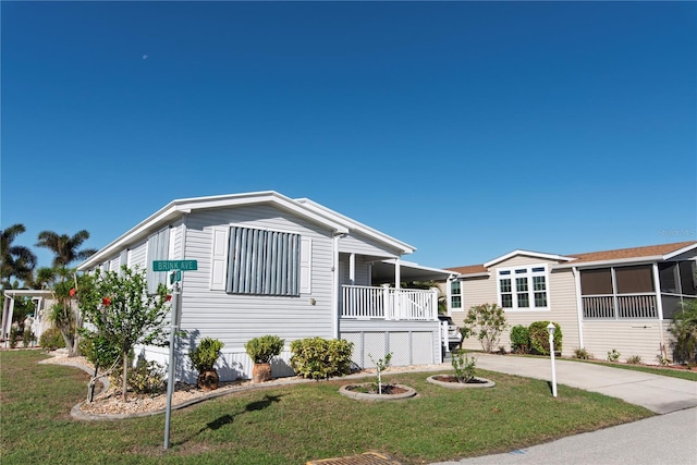 manufactured / mobile home featuring covered porch and a front yard