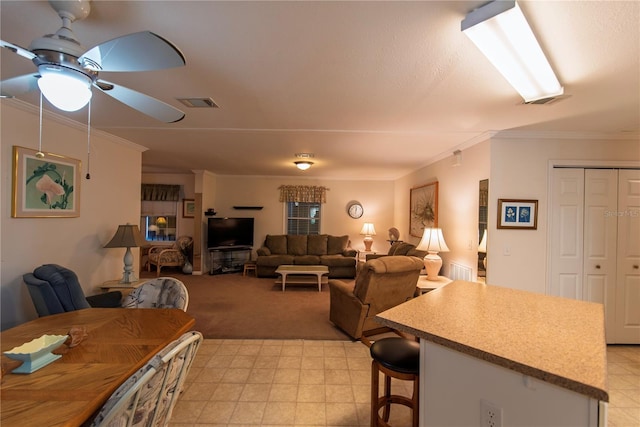 dining area featuring crown molding, ceiling fan, and light colored carpet