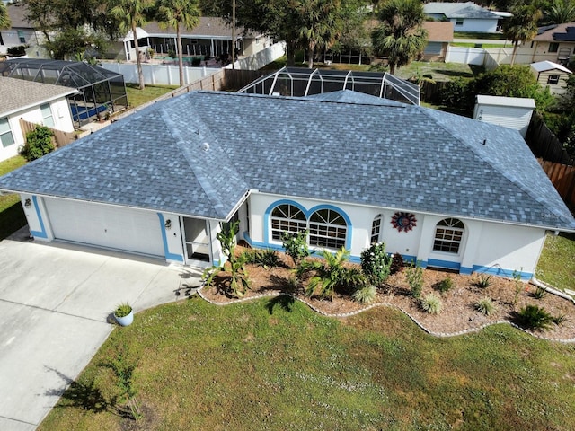 view of front of house with glass enclosure and a front lawn