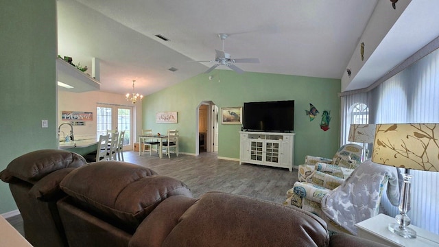 living room featuring hardwood / wood-style floors, ceiling fan with notable chandelier, and lofted ceiling