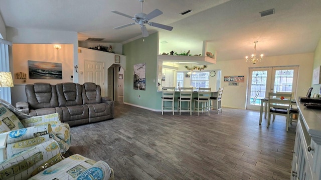 living room featuring french doors, ceiling fan with notable chandelier, vaulted ceiling, and dark wood-type flooring