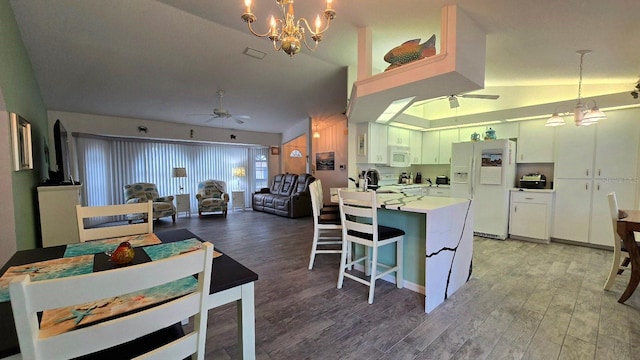 kitchen featuring ceiling fan with notable chandelier, white appliances, decorative light fixtures, hardwood / wood-style floors, and white cabinetry